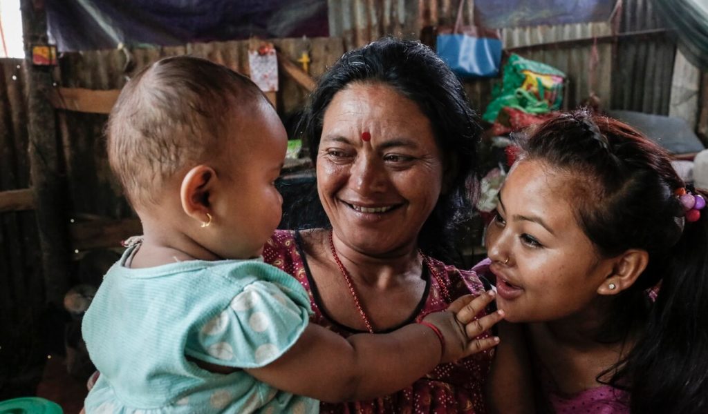Basanti Bista, 36, and Prabita Bista, 22, play with Prabita's 11-month-old baby in Salyantar, Nepal.