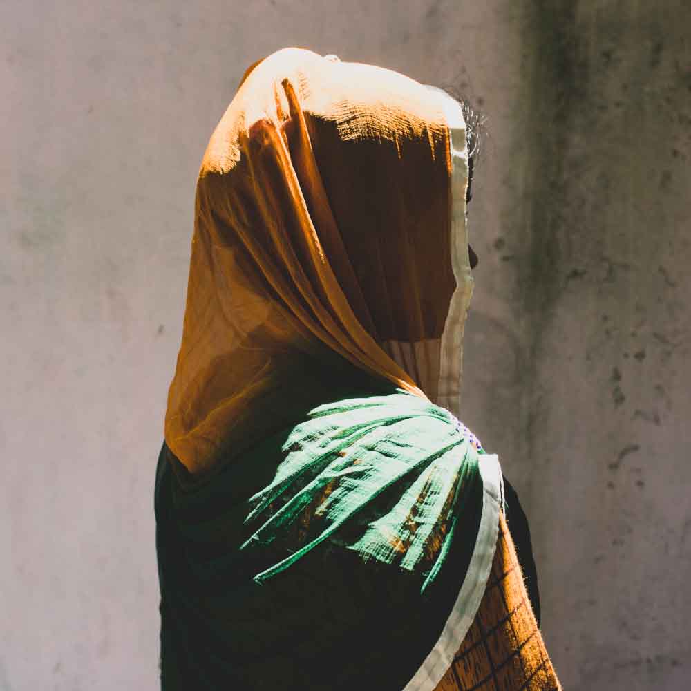 A profile of a veiled woman faces away from the camera.