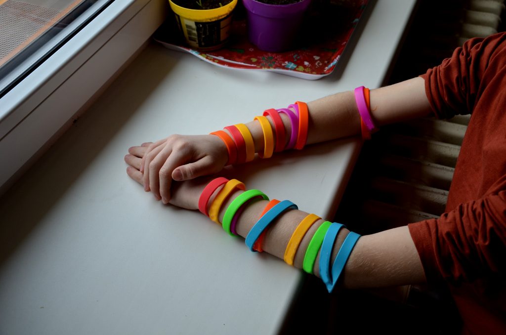 Child wearing rainbow bracelets