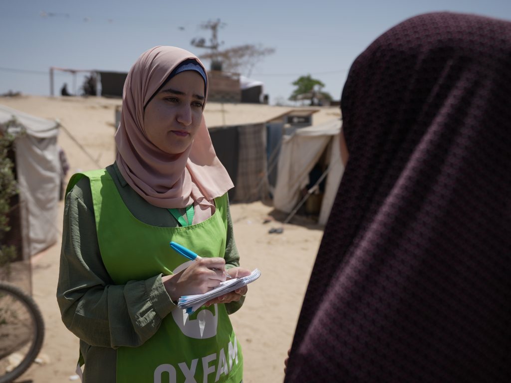 Ghada Alhaddad stands in the Al-Mawasi area, collecting notes and reflections from people on the ground.