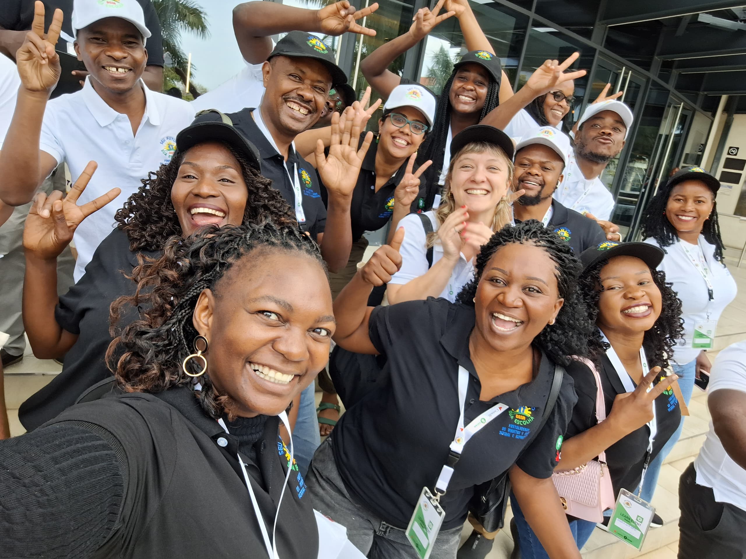 A group of people wearing Oxfam branded t-shirts and hats smile to the camera.