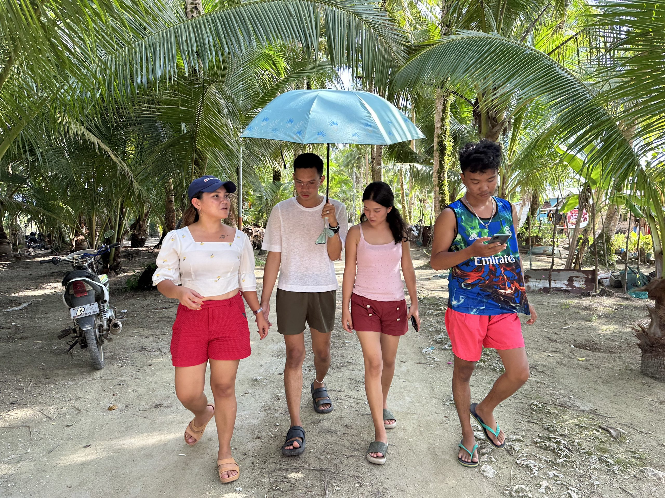 Marinel with her old time school and activist friends, Ariel, Reynalda and John, walking through Matarinao. Photo: Stories4Change by Climate Tracker/Oxfam