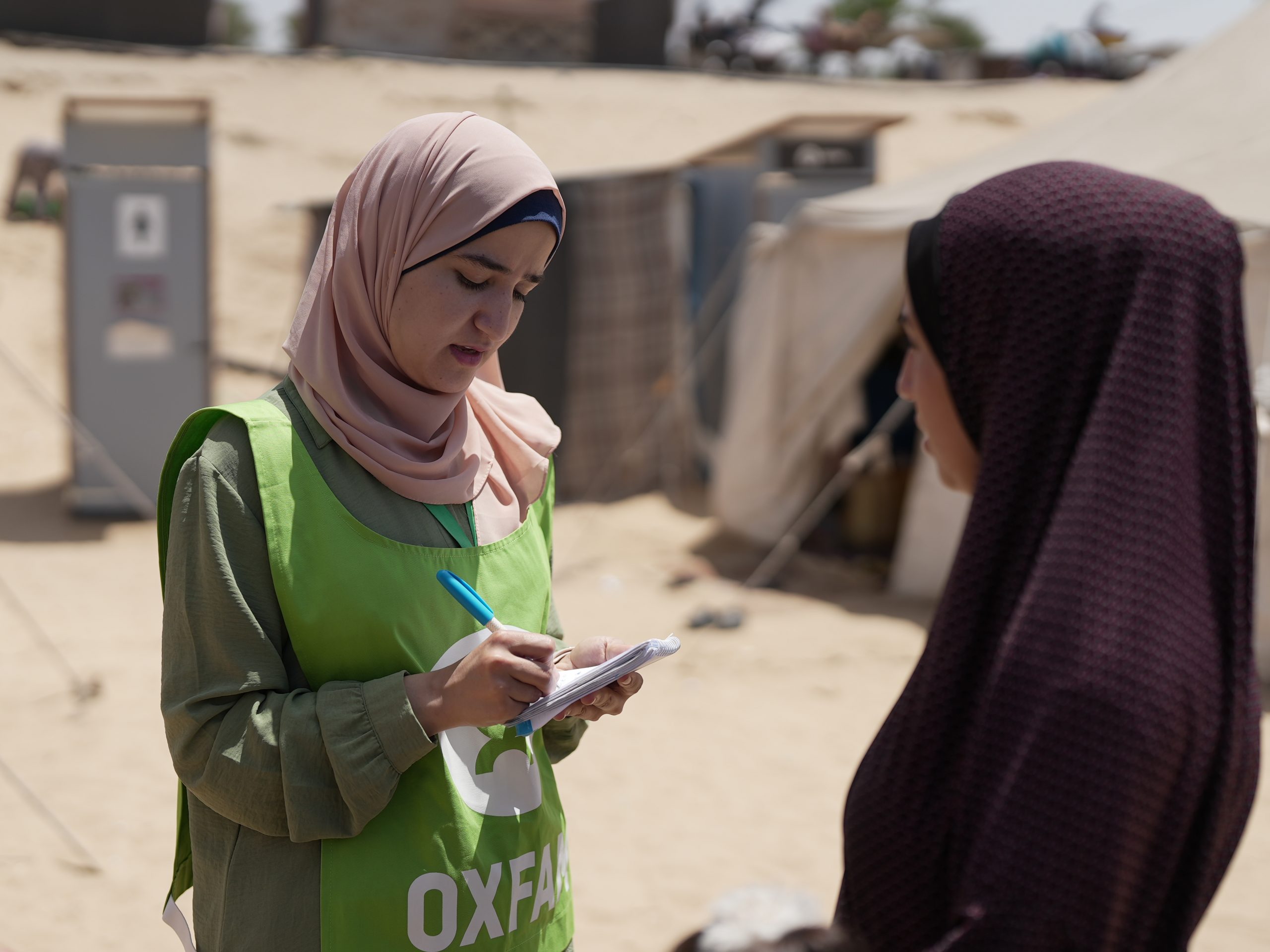 Ghada Alhaddad stands in the Al-Mawasi area, collecting notes and reflections from people on the ground. Photo: Alef Multimedia/Oxfam