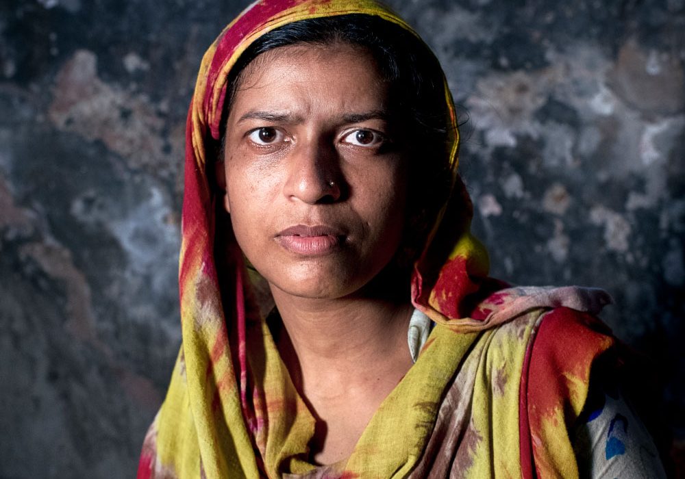 A woman with a serious expression faces the camera.