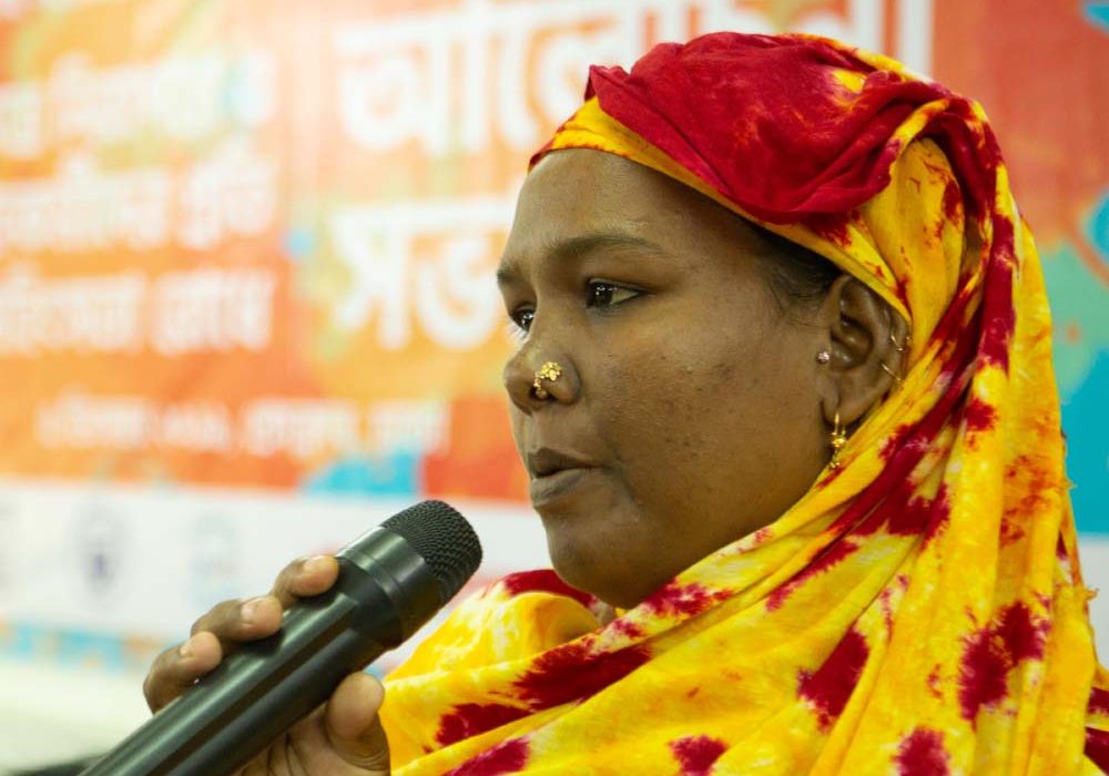 A woman is holding a microphone and speaking.